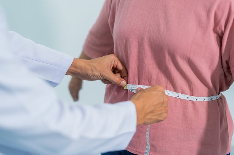 Close-up of a healthcare worker measuring an overweight woman's waist with tape, showing weight control, obesity risk, body size check, and healthy lifestyle support.